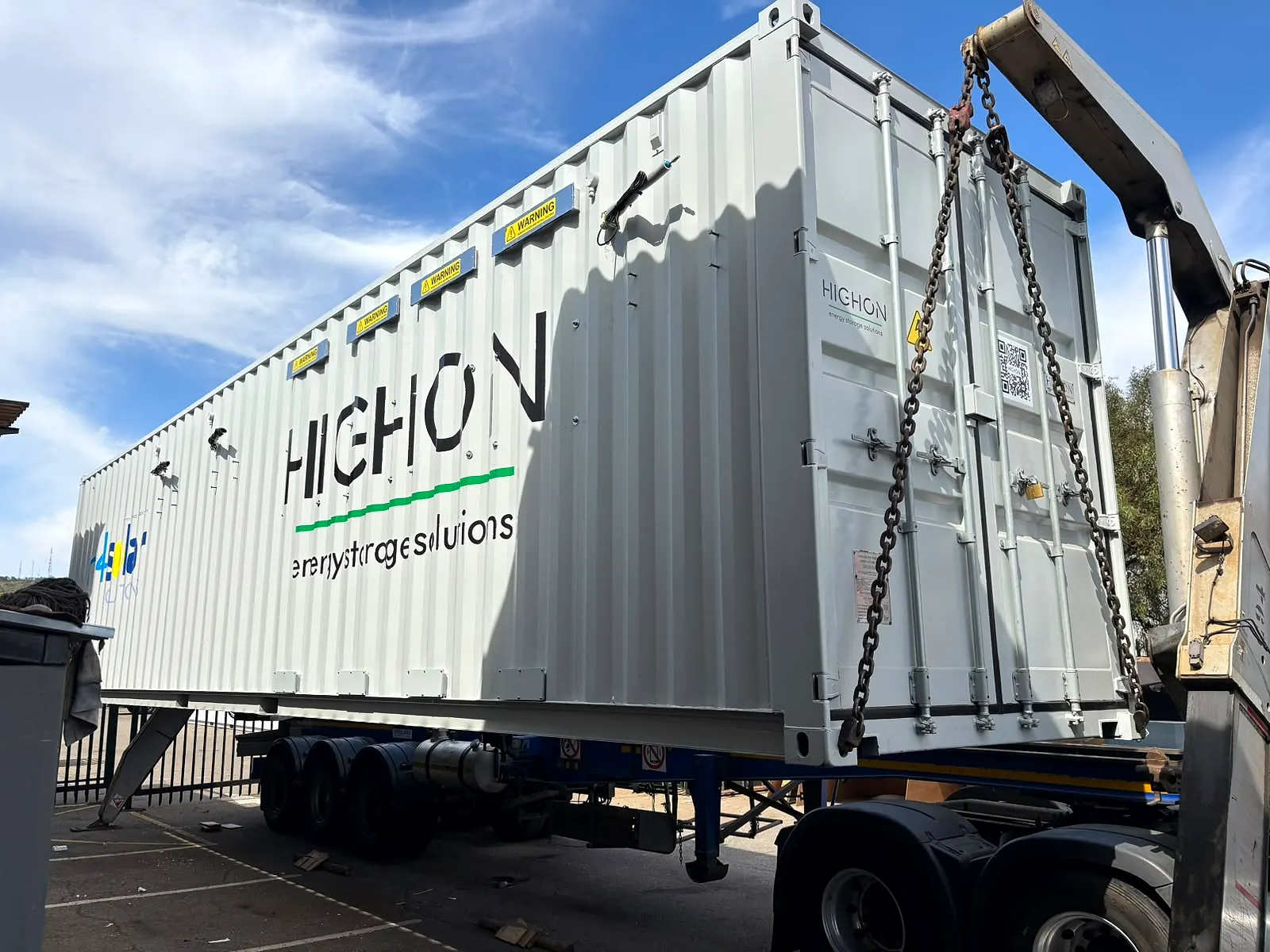 Steel battery container being lifted from its trailer